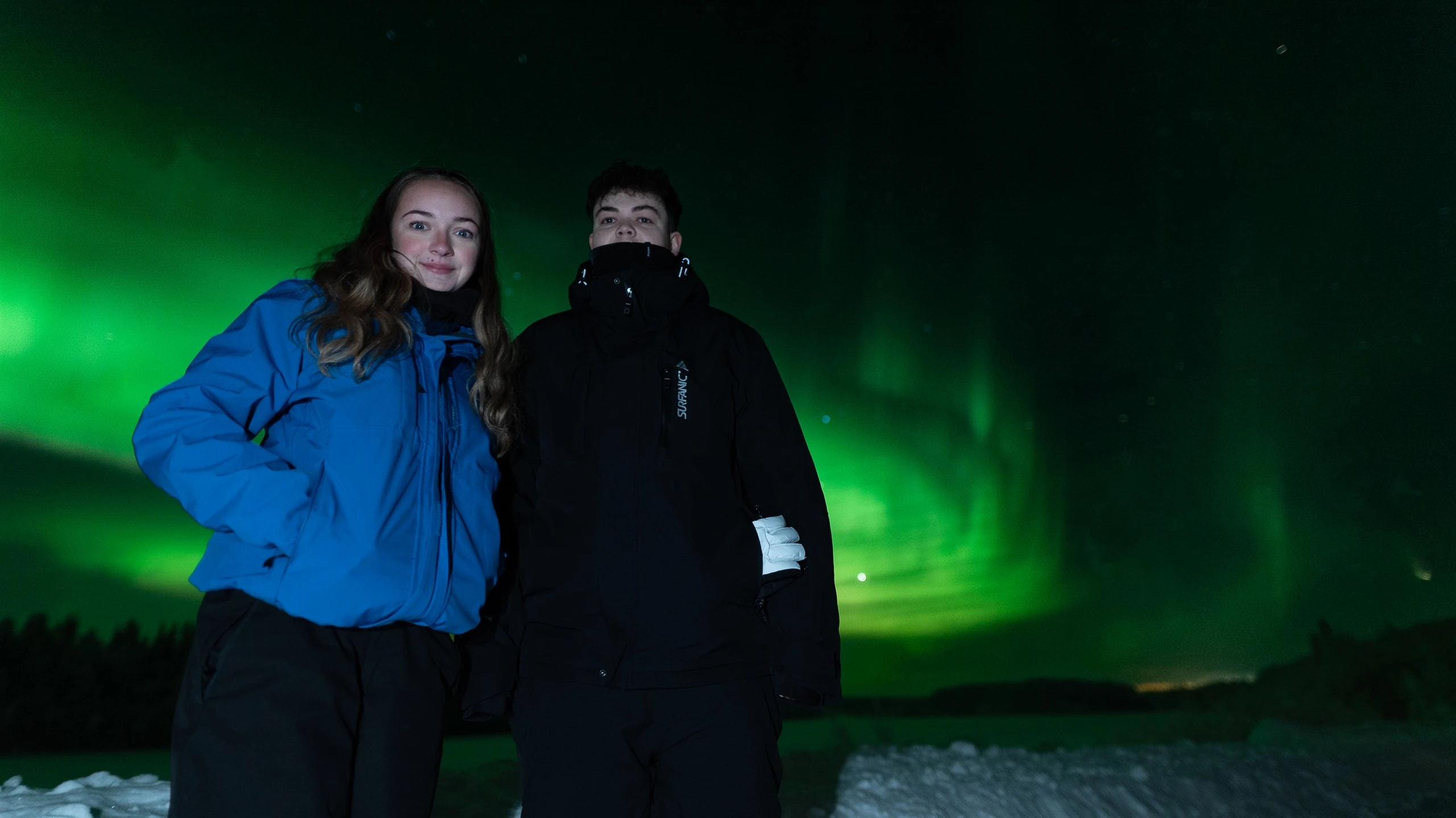 Couple smiling under the northern lights in Lapland